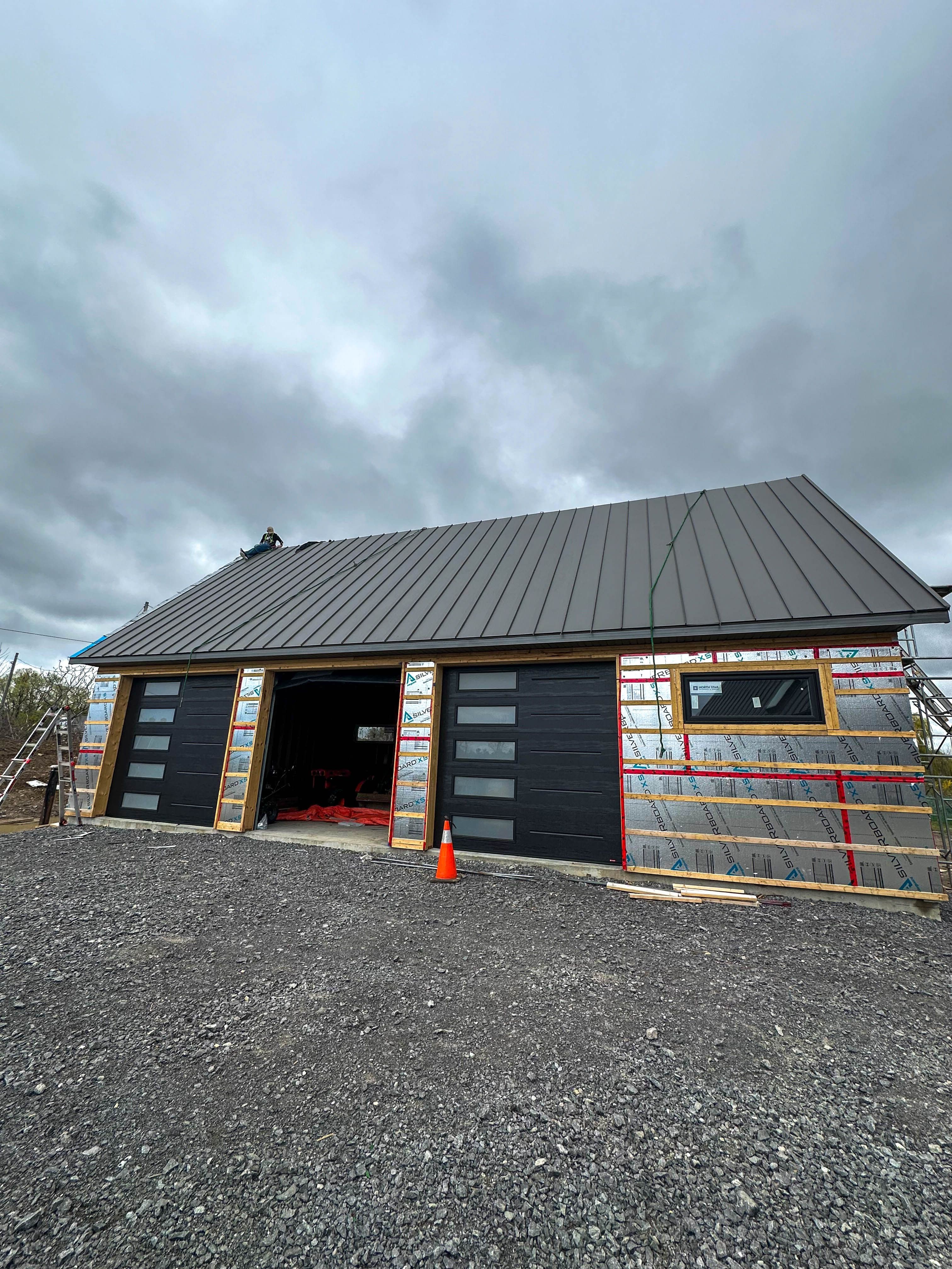 Close-up of modern exterior design showcasing metal roofing and Gentek Moderno siding in a sleek charcoal finish