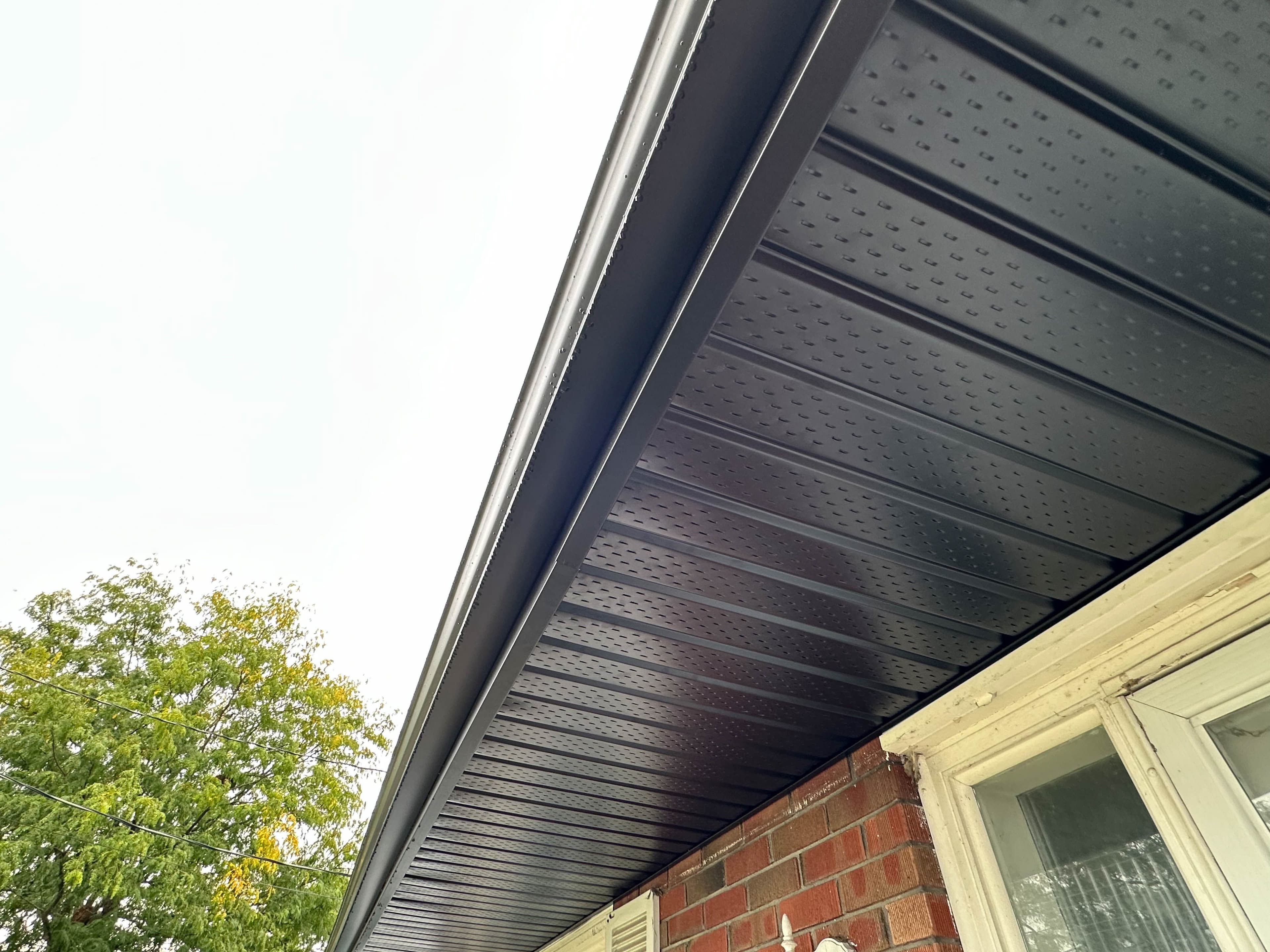 Detailed view of black aluminum soffit installation on a residential home in Belleville