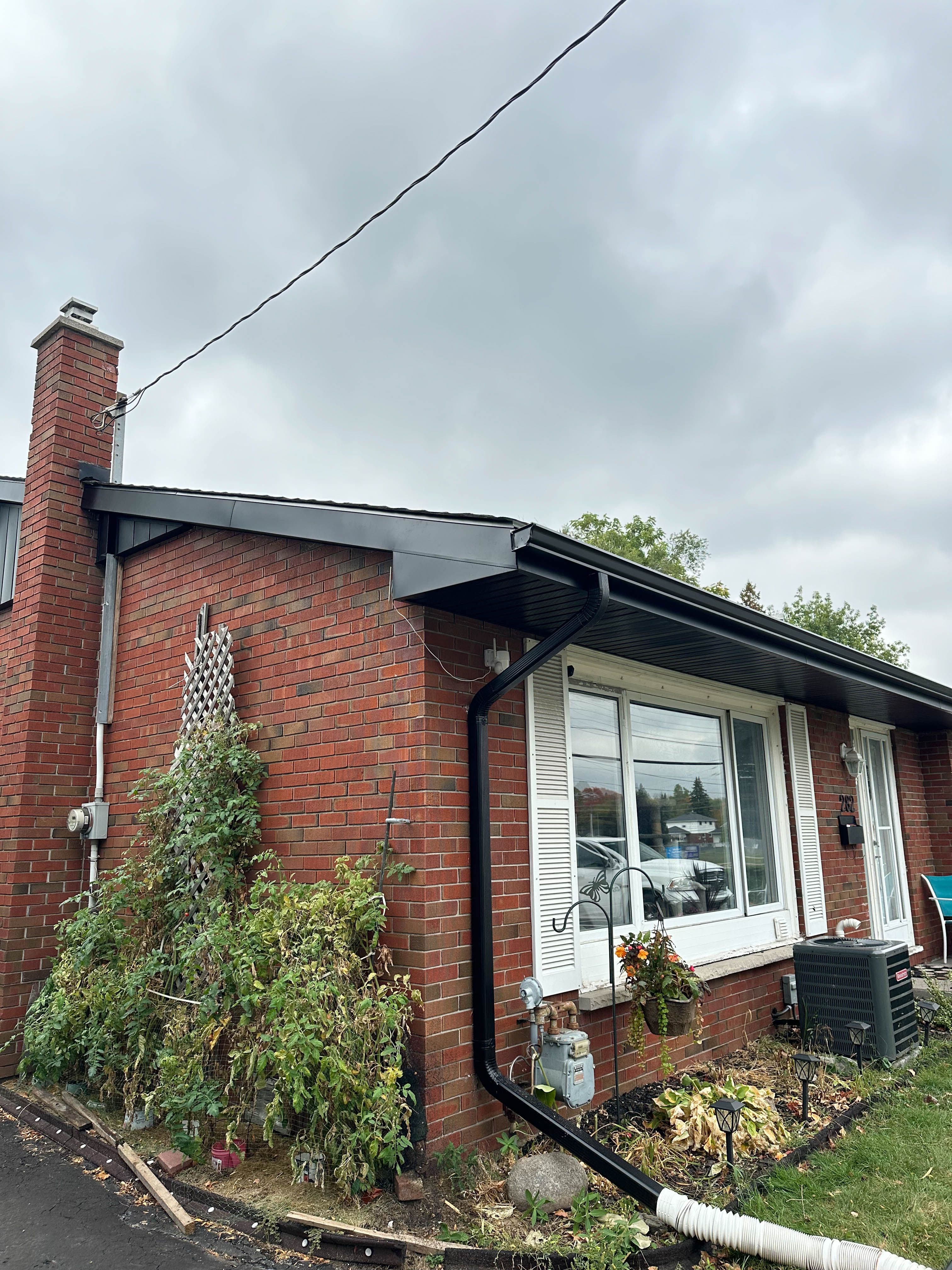 Side view of Belleville home showing updated eavestrough, fascia, and siding around windows and roofline